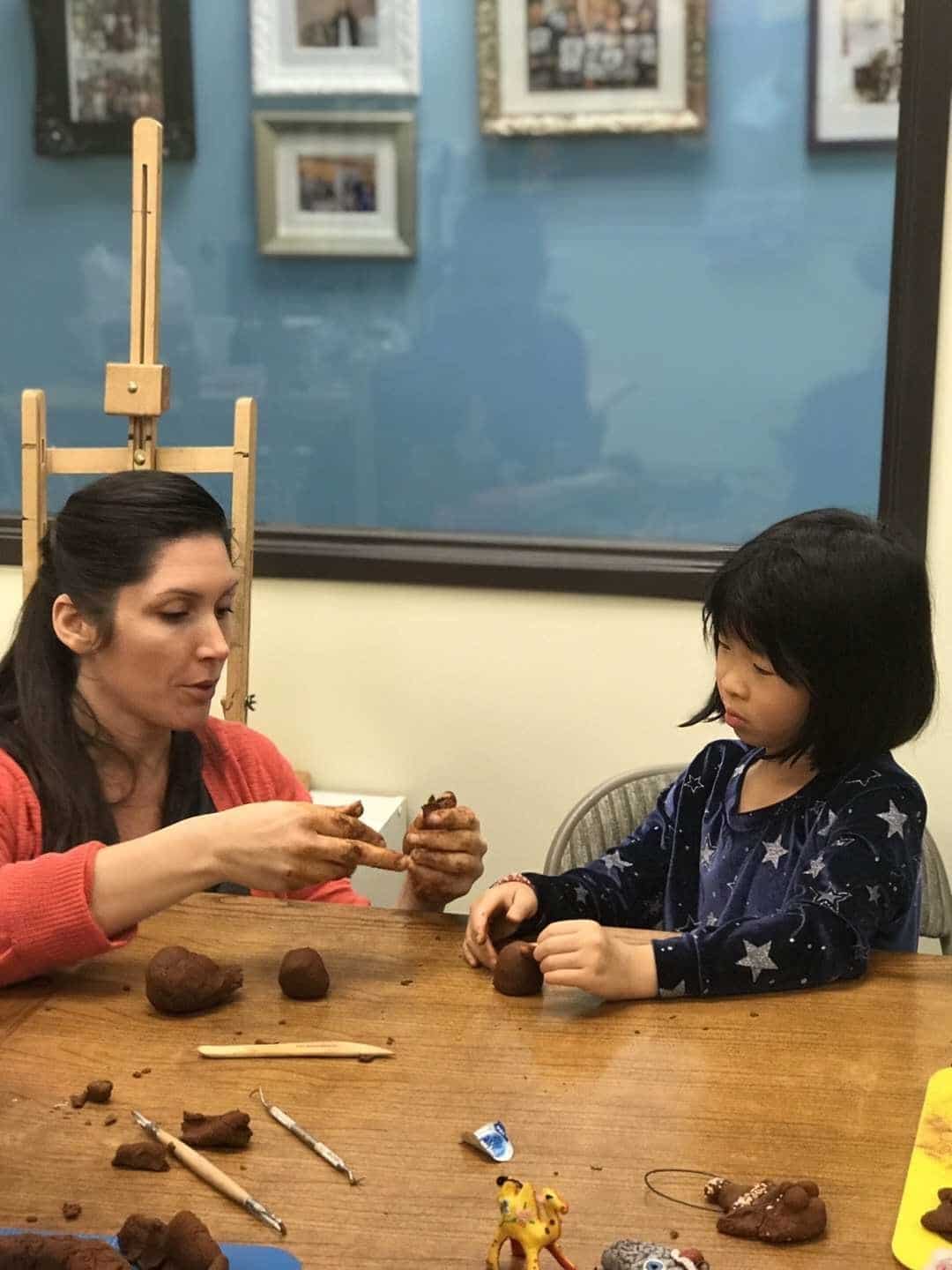 A teacher showing her students on how to craft clay