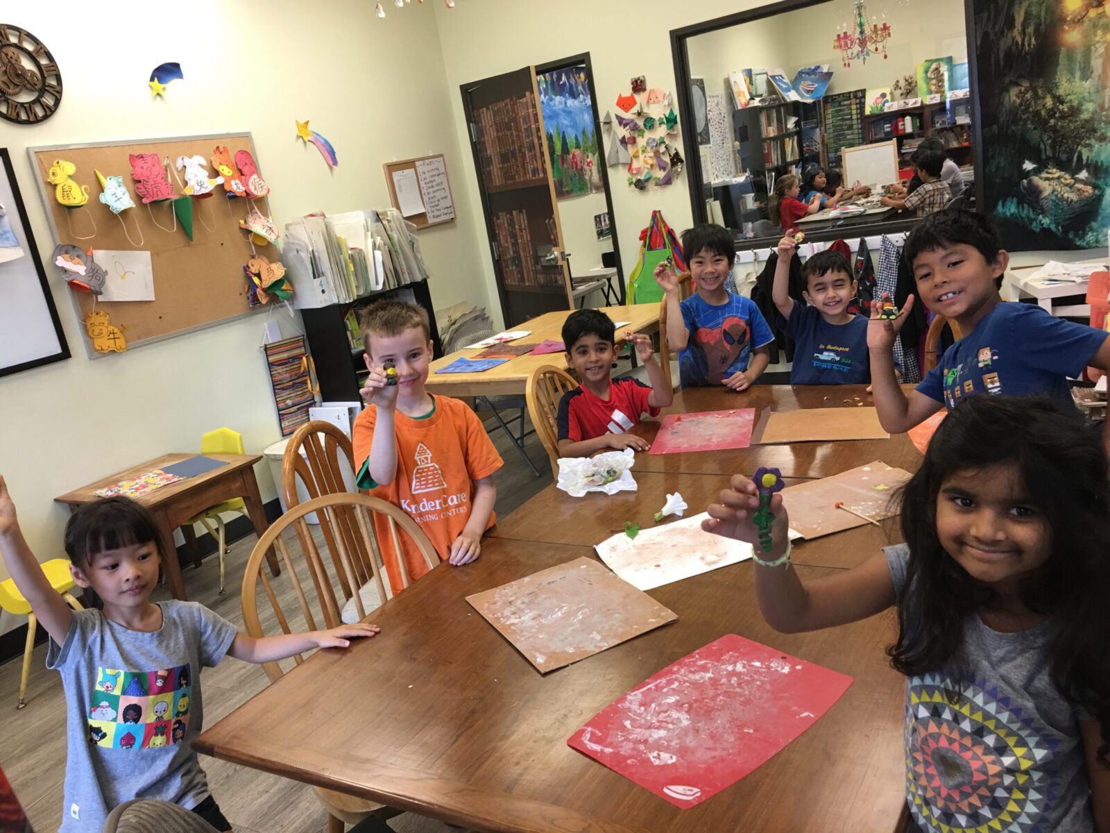 Kids happily showing their clay crafts